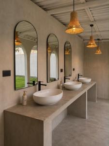 a bathroom with four sinks and three mirrors at Curve Ahangama in Ahangama