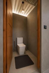 a bathroom with a white toilet in a room at Curve Ahangama in Ahangama