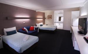 ein Hotelzimmer mit 2 Betten und einem Sofa in der Unterkunft Mayfair Motel in West Wyalong