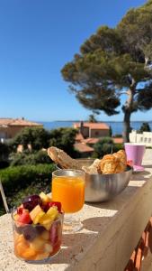 a table with a bowl of fruit and a glass of orange juice at Villa Esmeralda Adults Only in Les Issambres