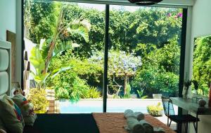 a living room with a large window with a view of a pool at The Green Retreat in Torres Vedras