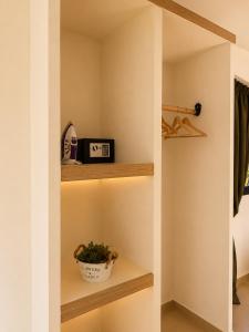 a room with shelves and a clock and a plant at Sea Salt Maisonettes Samos in Ireon