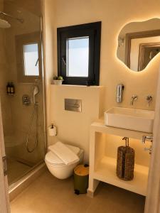a bathroom with a toilet and a sink and a shower at Sea Salt Maisonettes Samos in Ireon +46 photos