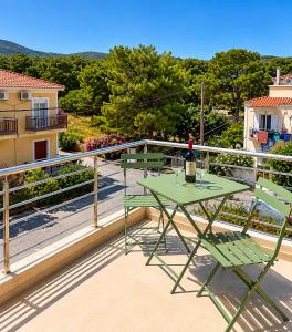 a table with a bottle of wine on a balcony at Sea Salt Maisonettes Samos in Ireon