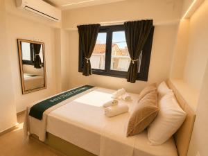 a bedroom with a bed with towels on it at Sea Salt Maisonettes Samos in Ireon