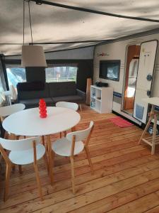 a living room with a table and chairs and a caravan at Słoneczne Przyczepy Dębki in Dębki
