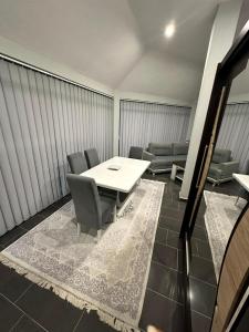 a room with a table and chairs and a couch at Halal Una Royal in Ivišovo Greblje
