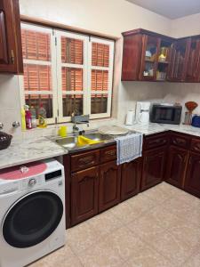 a kitchen with a sink and a washing machine at S Vicente Live in Mindelo