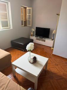 a living room with a white coffee table and a tv at S Vicente Live in Mindelo
