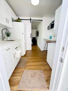a kitchen with white cabinets and a wooden floor at Private Suite with Laundry in Sunset