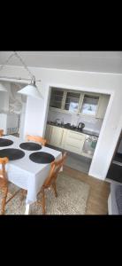 a dining room with a table and chairs and a kitchen at Apartament in Sykkylven