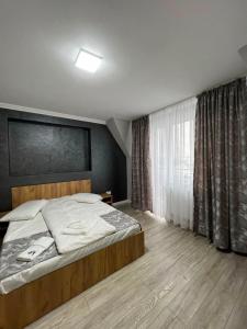 a bedroom with a large bed and a window at Achim-House in Beiuş