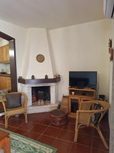 a living room with a fireplace and a television at Casa 3 Chamines in Vila Alva