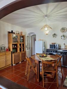 a kitchen with a table and chairs and a refrigerator at Casa 3 Chamines in Vila Alva