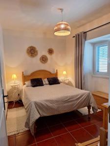 a bedroom with a bed and a chandelier at Casa 3 Chamines in Vila Alva