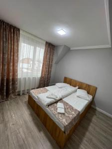 a bedroom with a bed in a room with a window at Achim-House in Beiuş
