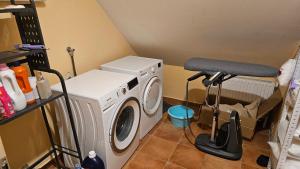 a laundry room with a washing machine and a stool at Tang Guesthouse in Medvode