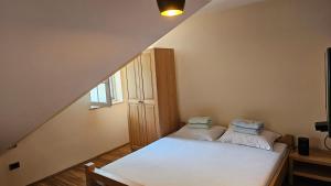 a small room with a bed in the attic at Tang Guesthouse in Medvode