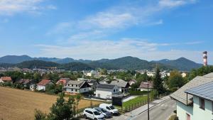 a city with cars parked in a town with mountains at Tang Guesthouse in Medvode