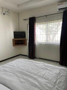 a bedroom with a white bed and a window at The Grace Villa in Abeokuta