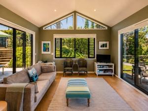 a living room with a couch and a large window at Art Lovers Retreat - Stay Waiheke in Onetangi