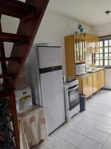 a kitchen with a refrigerator and a stove at Apartamento Salinas 2 quartos - Cidreira in Cidreira