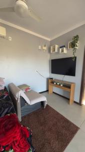 a living room with a tv and a couch at Kitnet beira da lagoa in Terra de Areia
