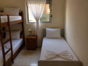 a small room with two beds and a window at Beachside Apartments Smajlaj in Velipojë