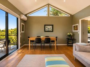 a living room with a table and a couch at Art Lovers Retreat - Stay Waiheke in Onetangi