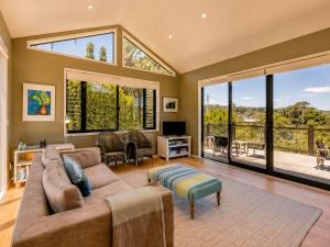 a living room with a couch and a large window at Art Lovers Retreat - Stay Waiheke in Onetangi