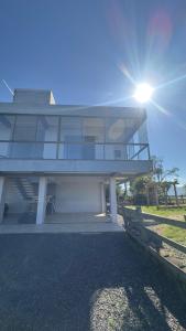 a large house with the sun shining on it at Kitnet beira da lagoa in Terra de Areia