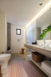 a bathroom with a sink and a toilet and a mirror at The Tryst Puerto Vallarta LGBT Hotel in Puerto Vallarta +50 photos