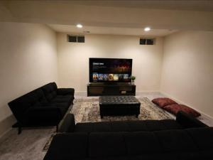 a living room with a couch and a flat screen tv at Spacious Studio by the Woods in Laurel