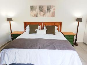a bedroom with a large bed with two night stands at The Tee Box in Southbroom