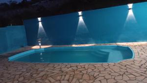 a swimming pool in the middle of a blue building at Cantinho,RMA in Bom Jesus dos Perdões