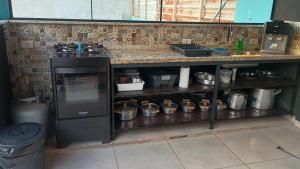 a kitchen with a stove and a counter with pots and pans at Cantinho,RMA in Bom Jesus dos Perdões