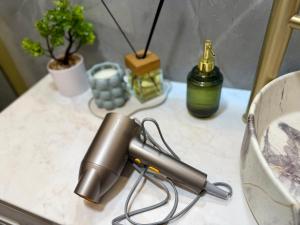 a hair dryer on a table with plants and bottles at The Emerald Loft I Terrace I Free Parking in Kaunas