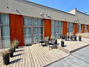 a building with chairs and tables on a wooden deck at The Emerald Loft I Terrace I Free Parking in Kaunas