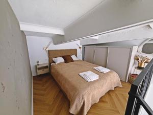a bedroom with a large bed with two towels on it at The Emerald Loft I Terrace I Free Parking in Kaunas