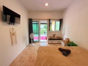 a bedroom with a bed and a flat screen tv at Serenity House with Large terrace in Ban Nok