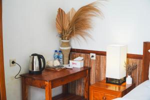 a bedroom with a table with a plant on it at De Sila House and Pool in Tembuku