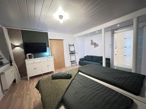 a bedroom with a bed and a flat screen tv at Suite House - Magnolia - Oak - Sage in Bayreuth