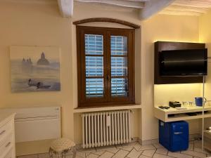 a room with a window and a desk and a television at 27 Arte Bientina in Bientina +41 photos