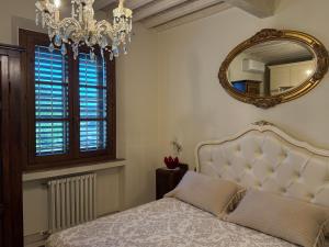 a bedroom with a bed with a mirror and a chandelier at 27 Arte Bientina in Bientina