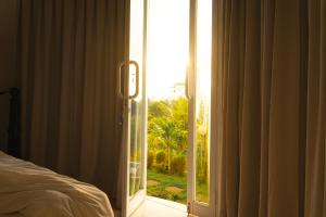 a bedroom with a door open to a window at De Sila House and Pool in Tembuku +10 photos