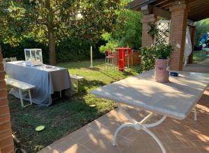 a picnic table in a yard with a table and chairs at 27 Arte Bientina in Bientina