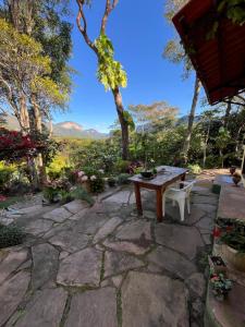 a stone patio with a wooden table and chairs at Casa de Marina in Palmeiras