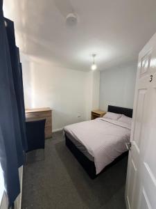 a bedroom with a bed and a dresser and a door at 10 wyeverne road in Cardiff