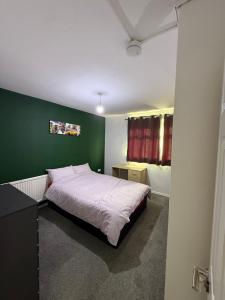 a bedroom with a bed with a green wall at 10 wyeverne road in Cardiff