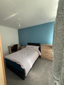 a bedroom with a bed and a blue wall at 10 wyeverne road in Cardiff +4 photos